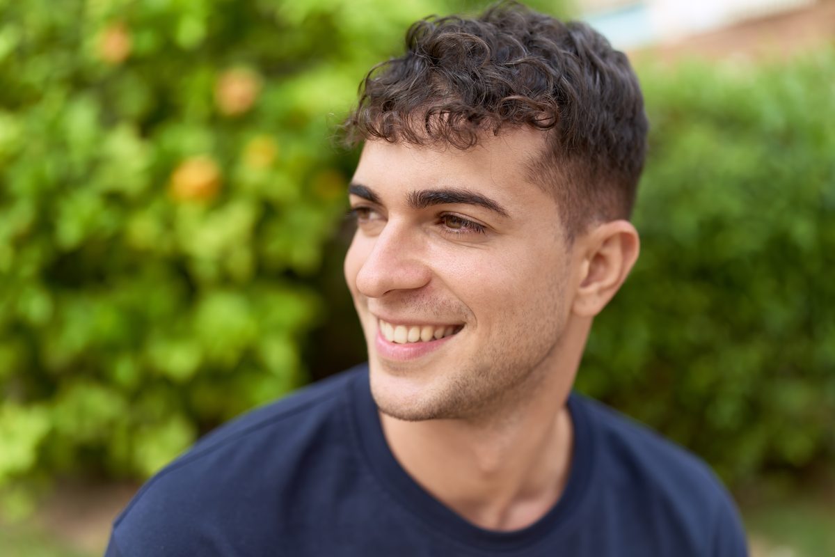 Young man smiling outdoors in a park