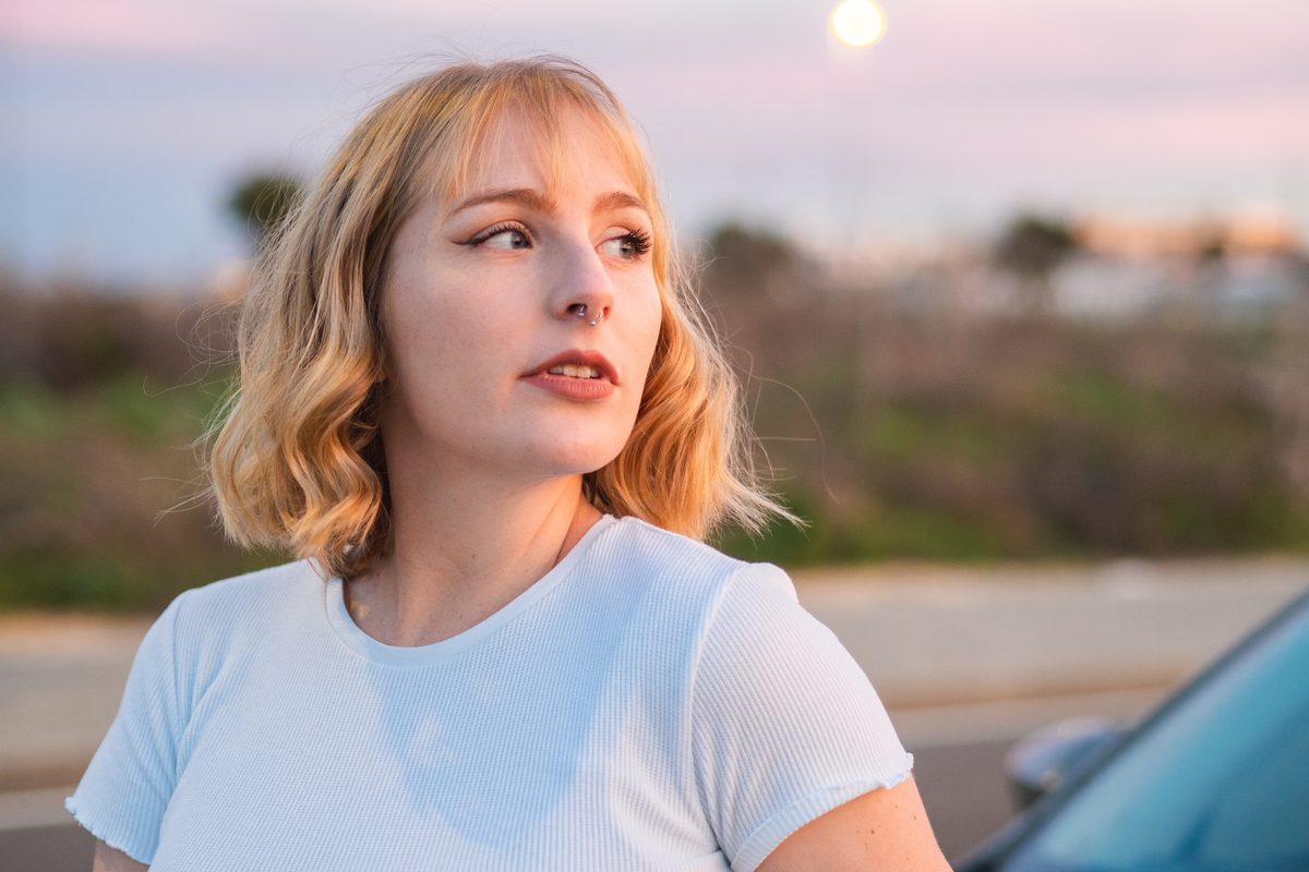 Young woman outdoors looking reflective in soft evening light