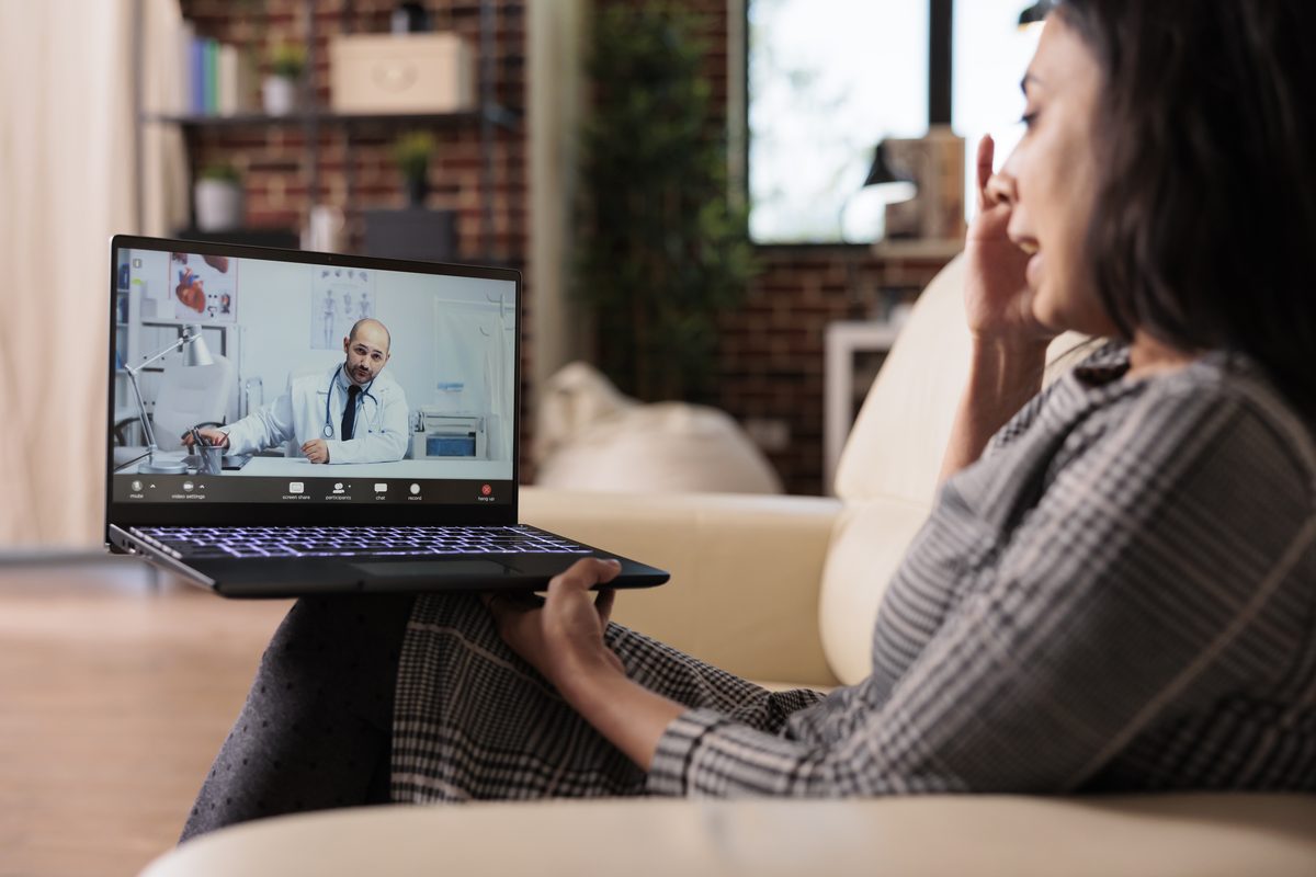 Young adult on a telehealth video call with a doctor at home