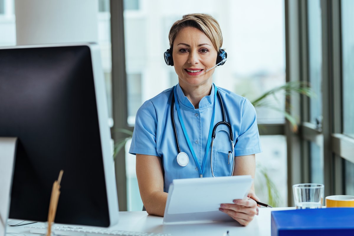 A friendly GP talks with a patient by phone