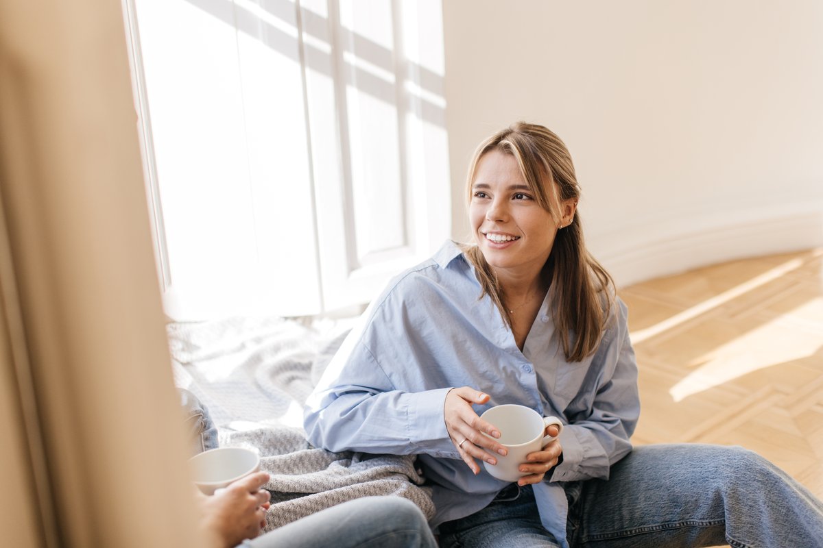 A woman relaxes calmly at home, looking reassured