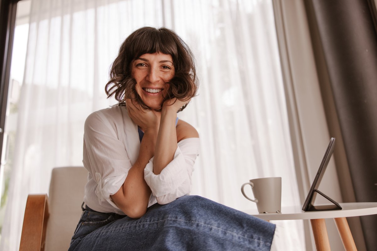 A confident woman smiles at home